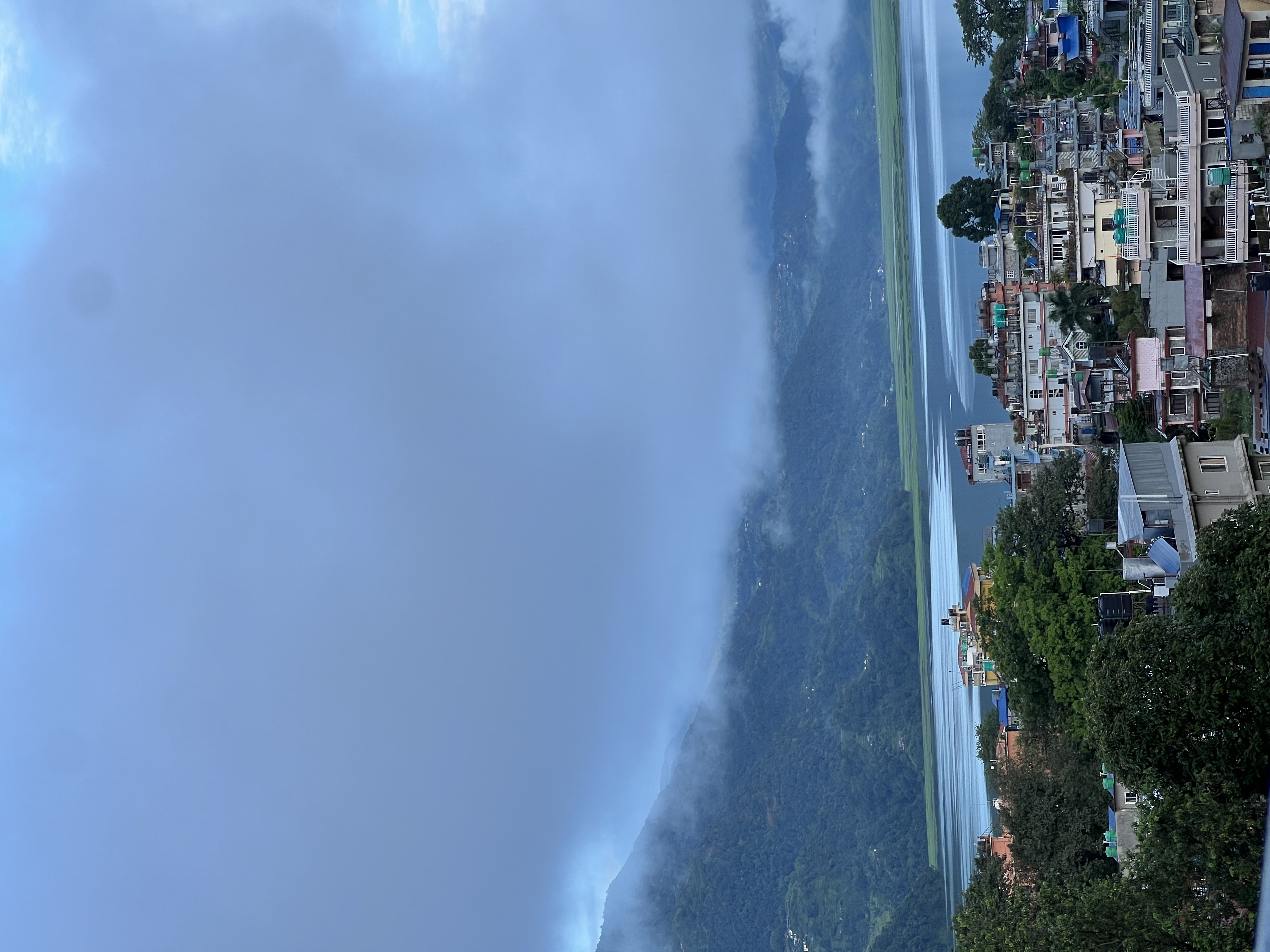 Phewa Lake with traditional boats and mountain reflections